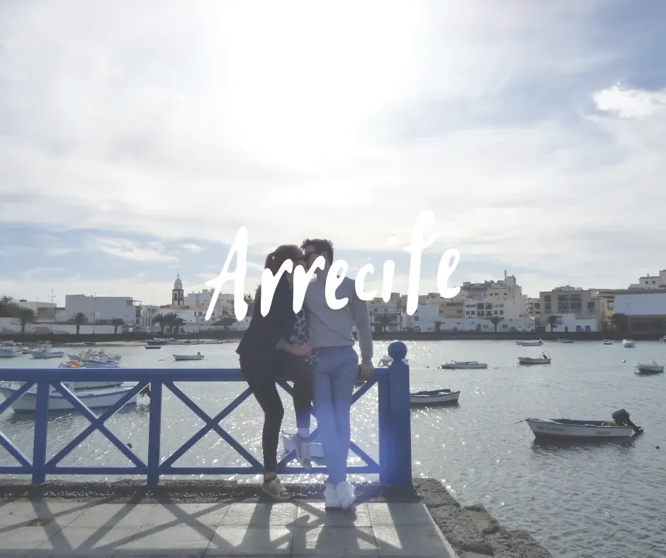 Couple leaning on the blue railing in front of the lagoon