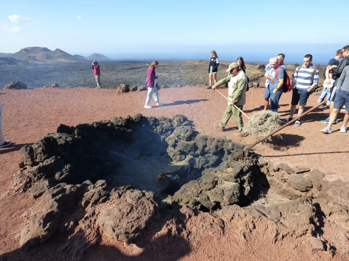 Visiteurs sur un sentier ocre au bord d'une fosse de lave