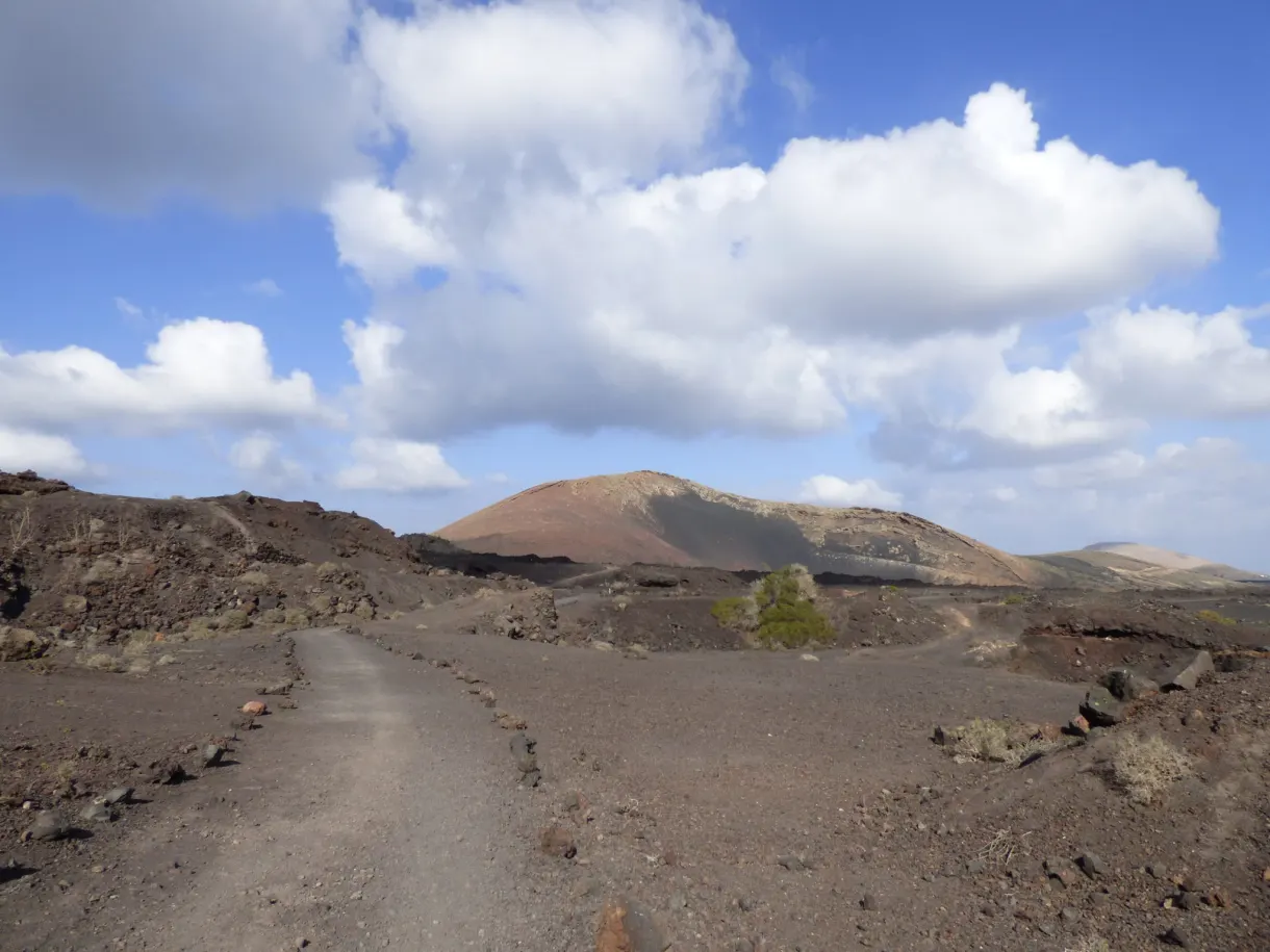 Piste de terre serpentant vers un cône orangé