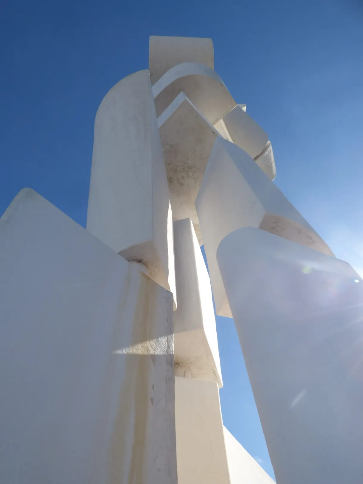 Contre-plongée sur les volumes blancs de la sculpture