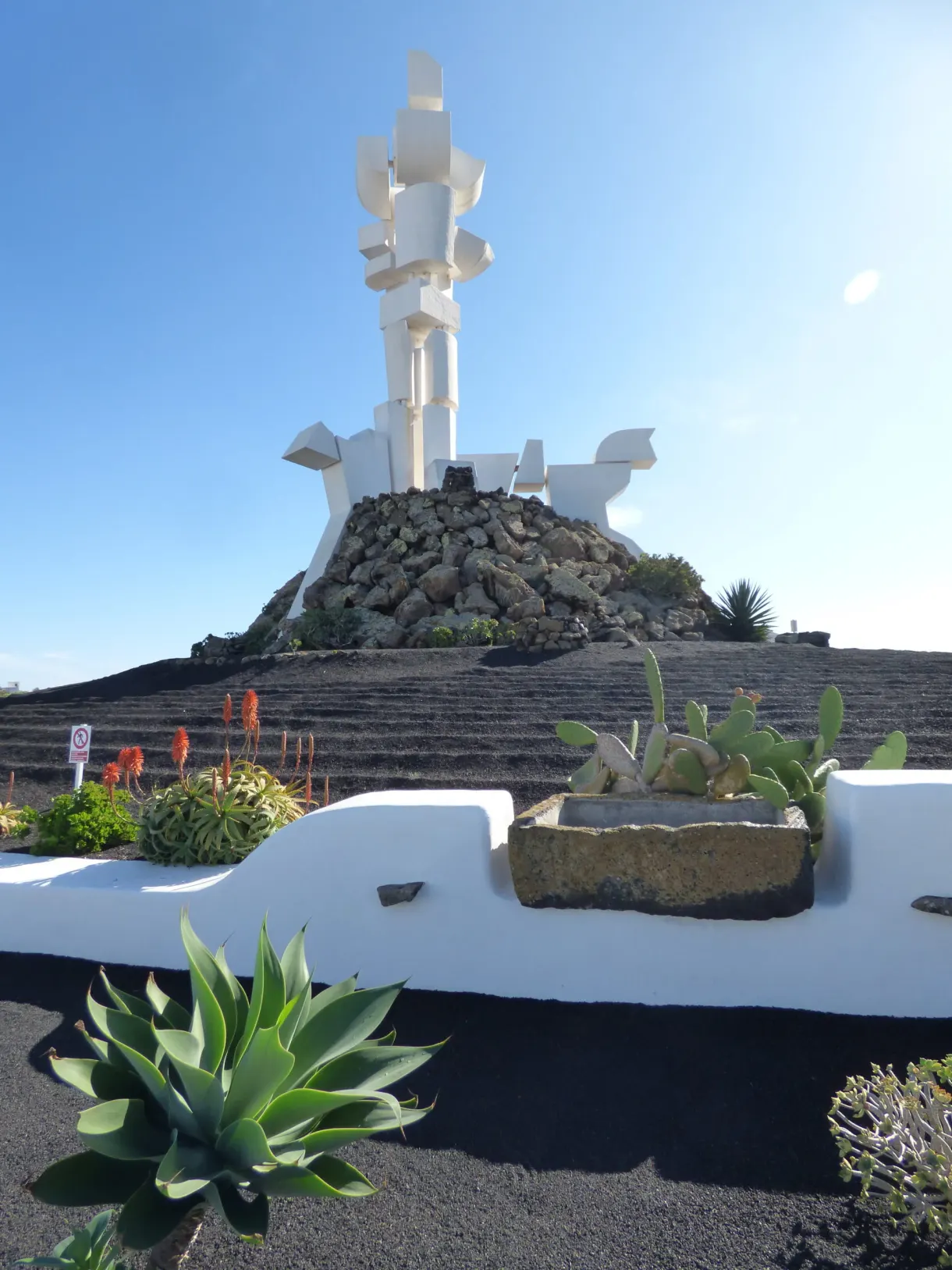 Monument blanc dominant un jardin d'agaves et de cactus