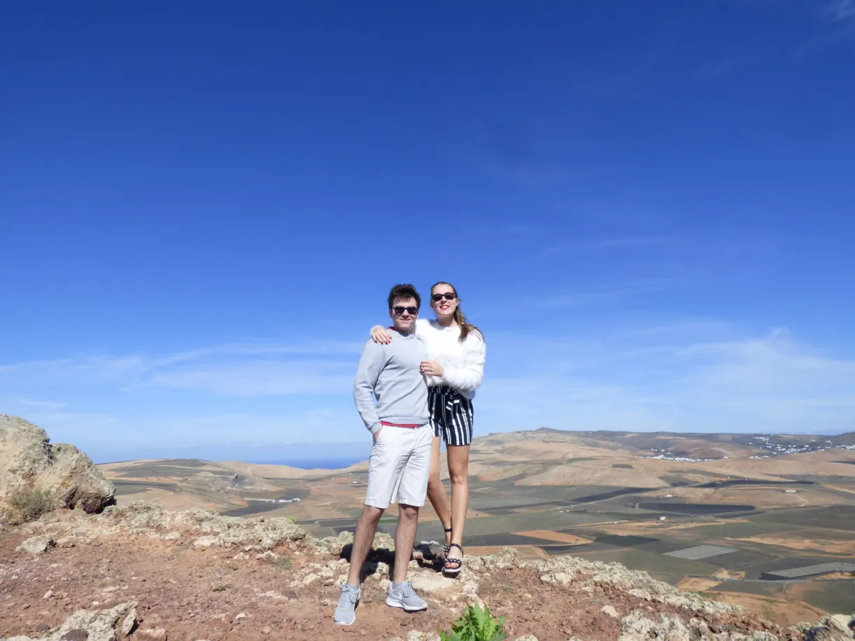 Couple posant devant les champs cultivés en contrebas