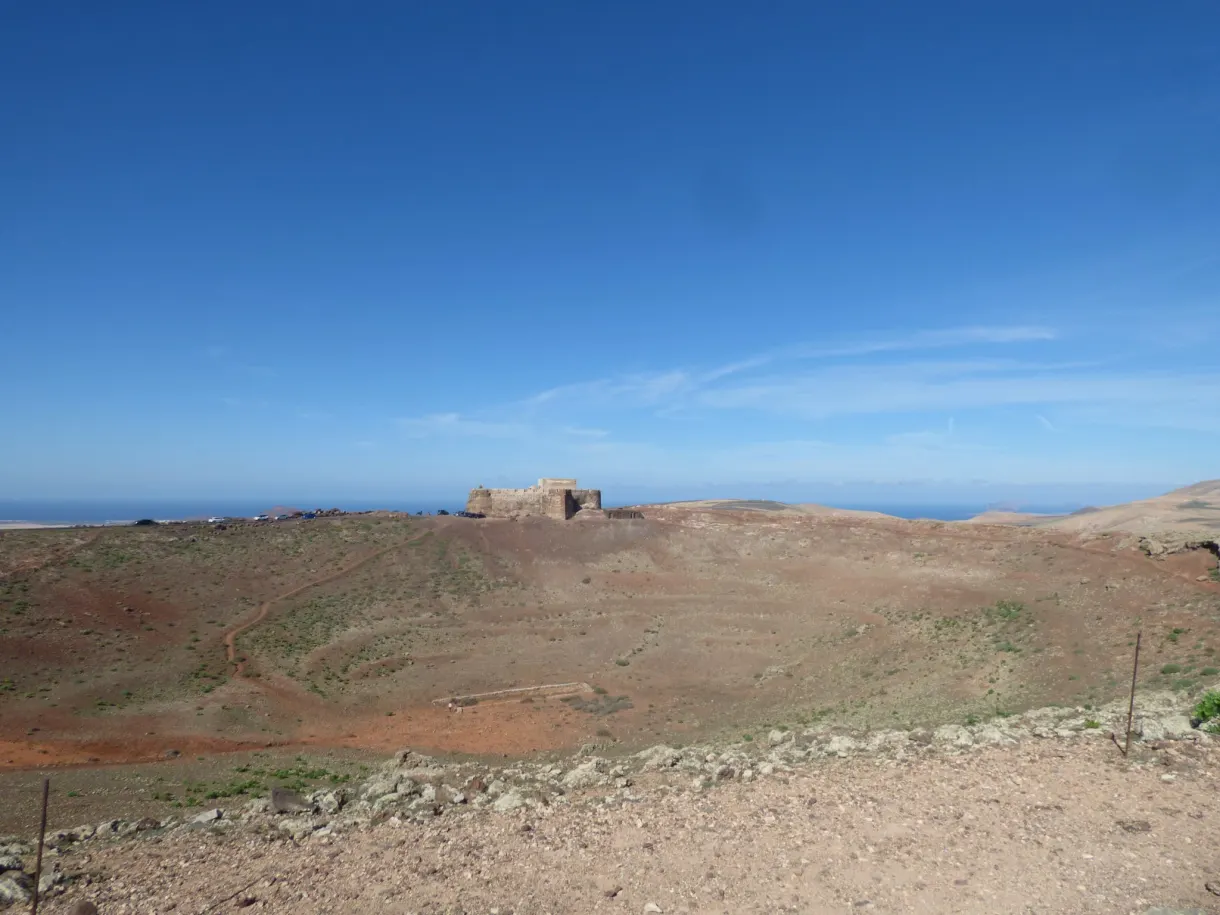 Château trapu posé sur la crête du volcan