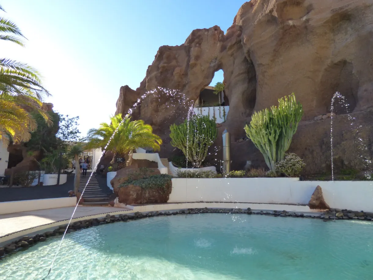 Arche de roche surplombant le bassin et ses jets d'eau
