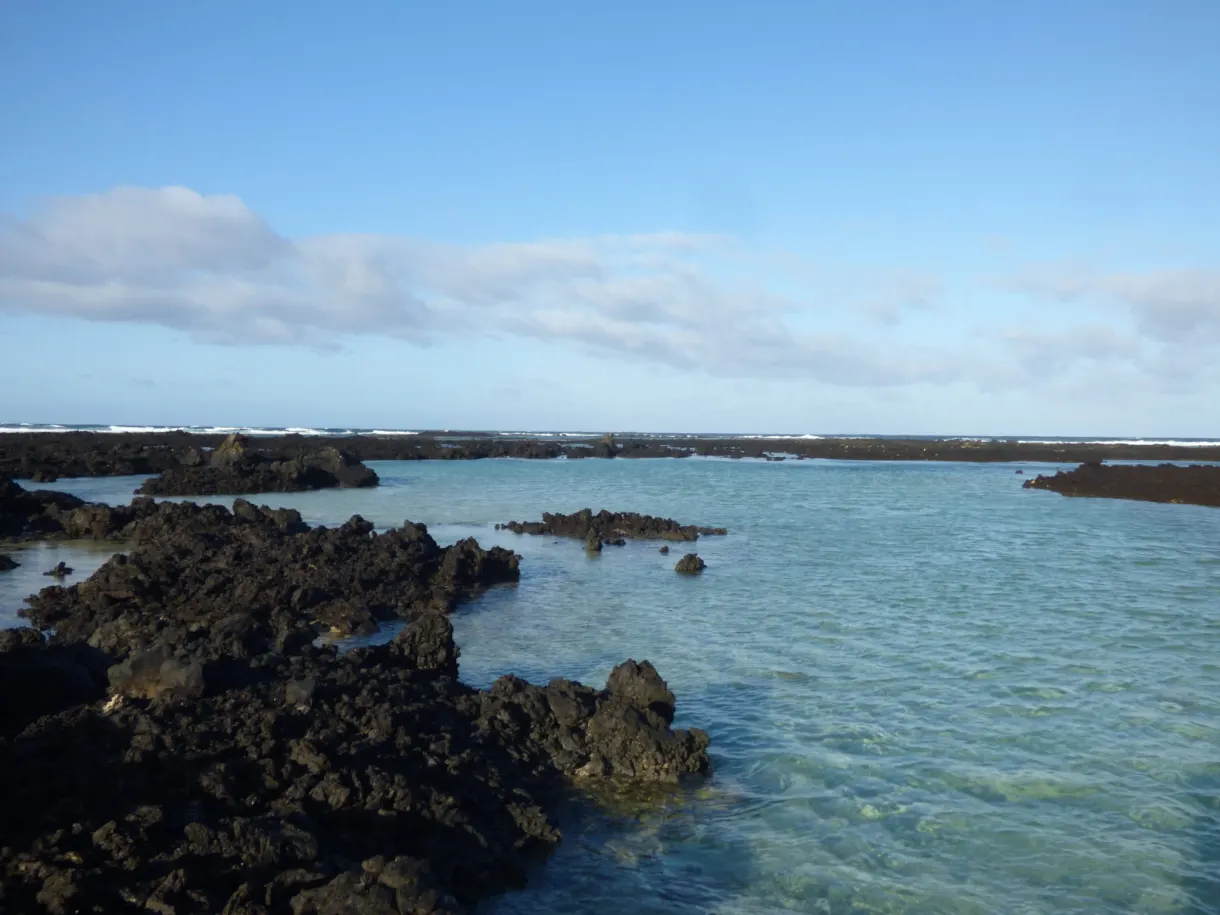 Récif de lave noire cerné d'une eau turquoise