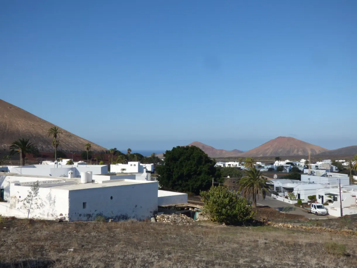 Toits blancs du village devant les collines et l'océan