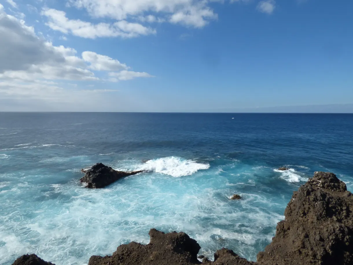 Vagues turquoise s'écrasant sur les rochers de basalte