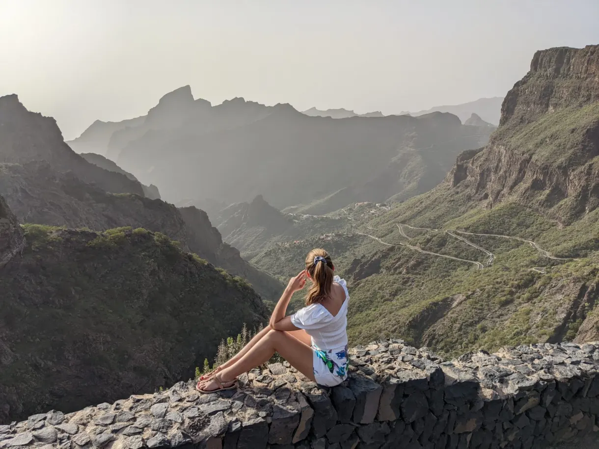 Femme assise sur un muret face aux montagnes de Teno