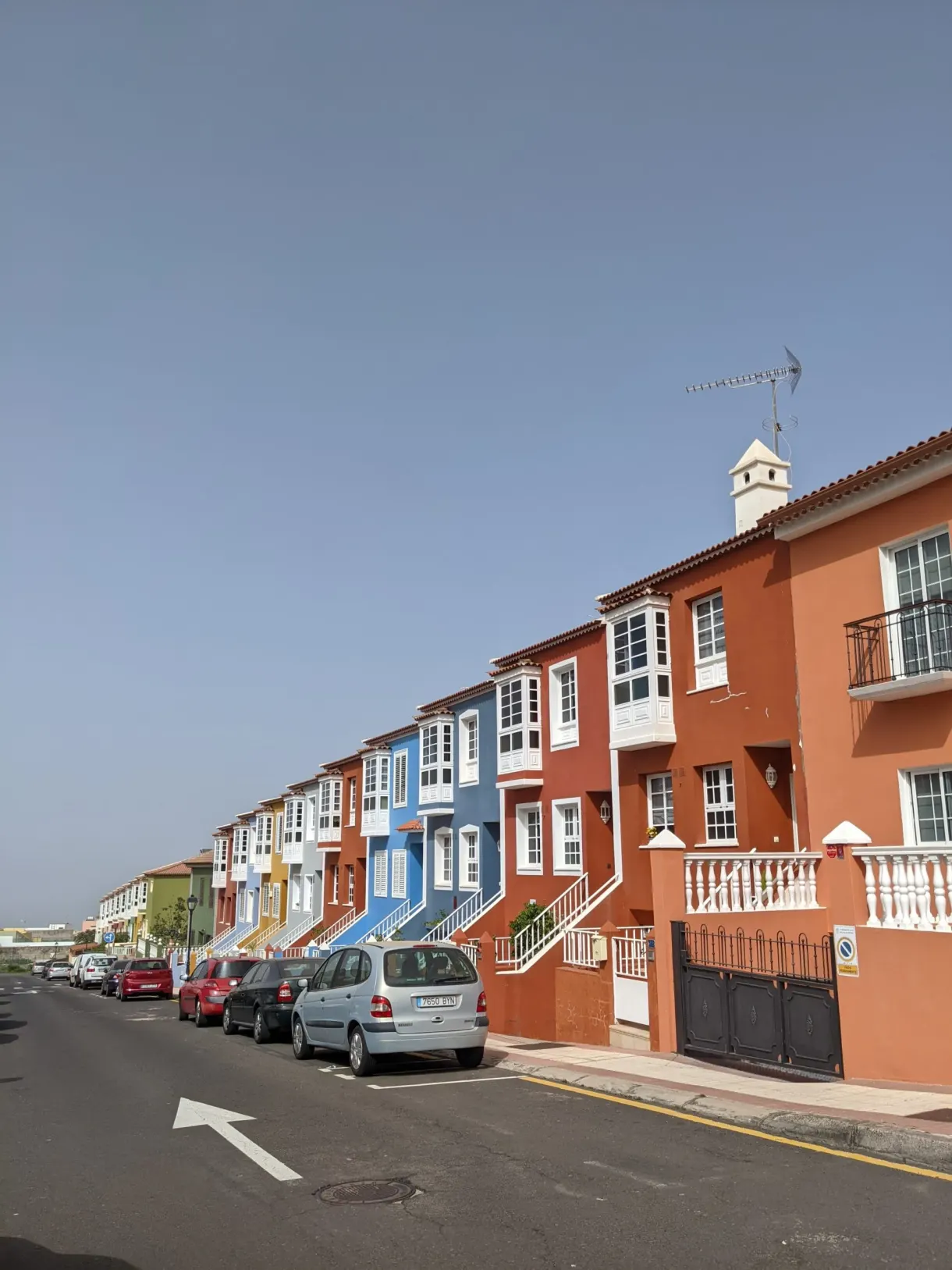 Rangée de maisons rouges et bleues au bord d'une rue