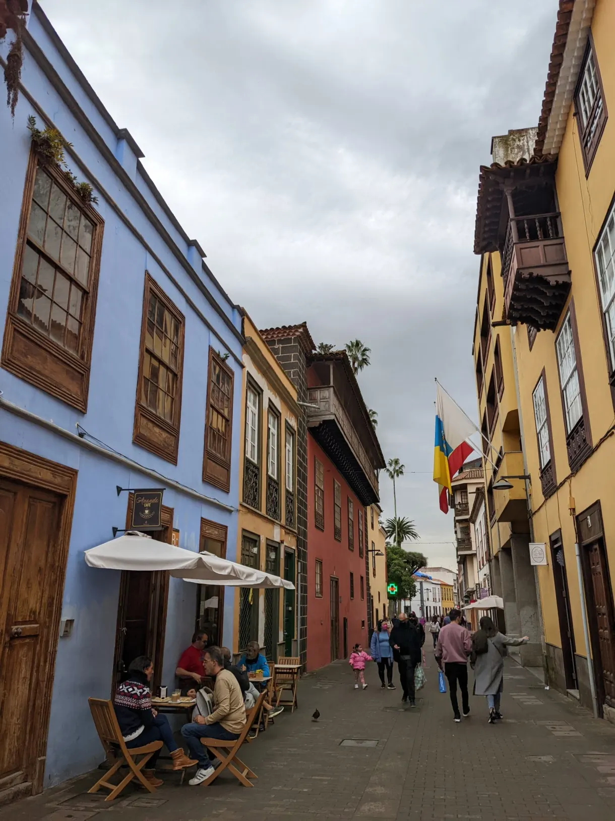 Terrasse de café devant une façade bleue de La Laguna