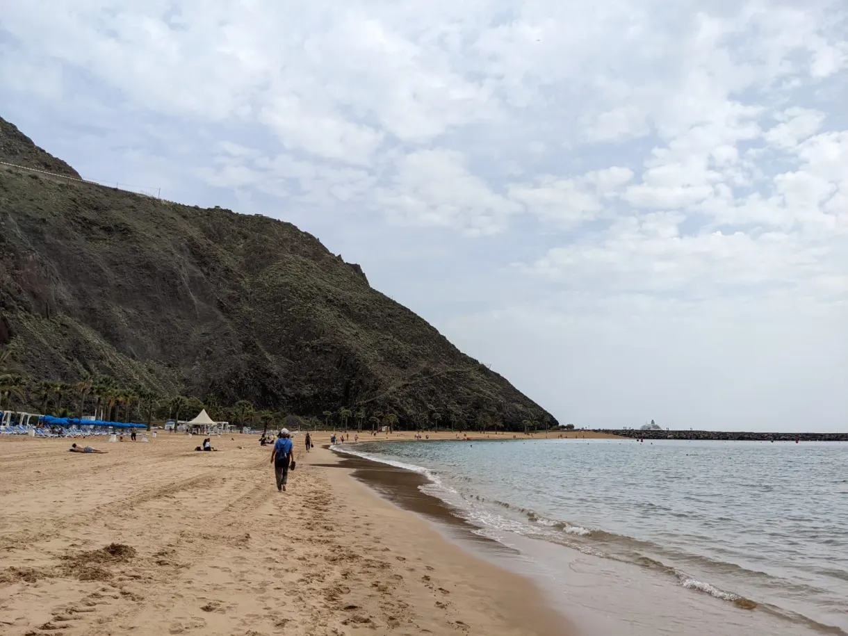Promeneur solitaire sur le sable au pied de la montagne