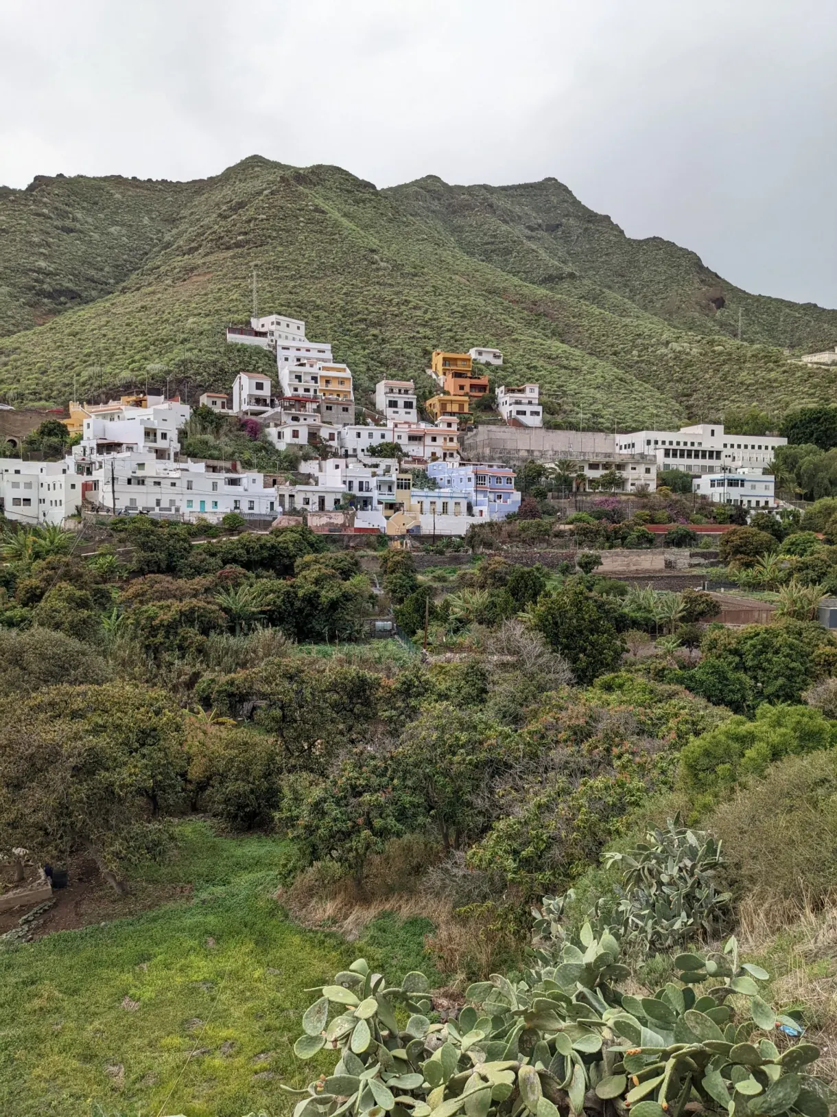 Village blanc étagé à flanc de colline verte