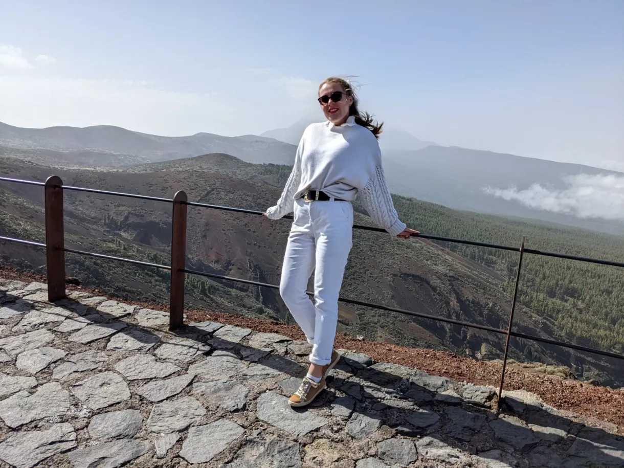 Woman traveller leaning against the railing of a paved mirador
