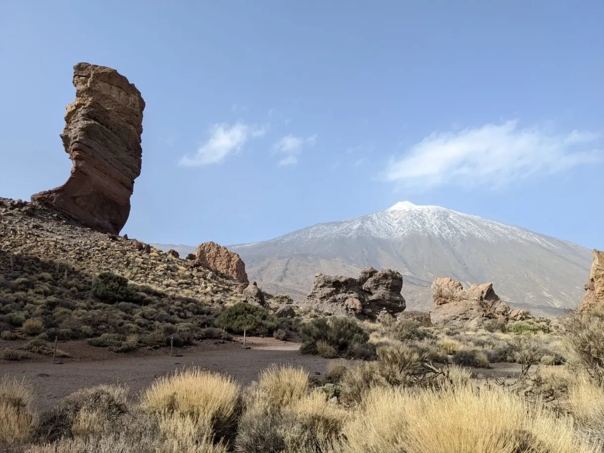 Rock standing in front of the snow-capped cone of the Teide