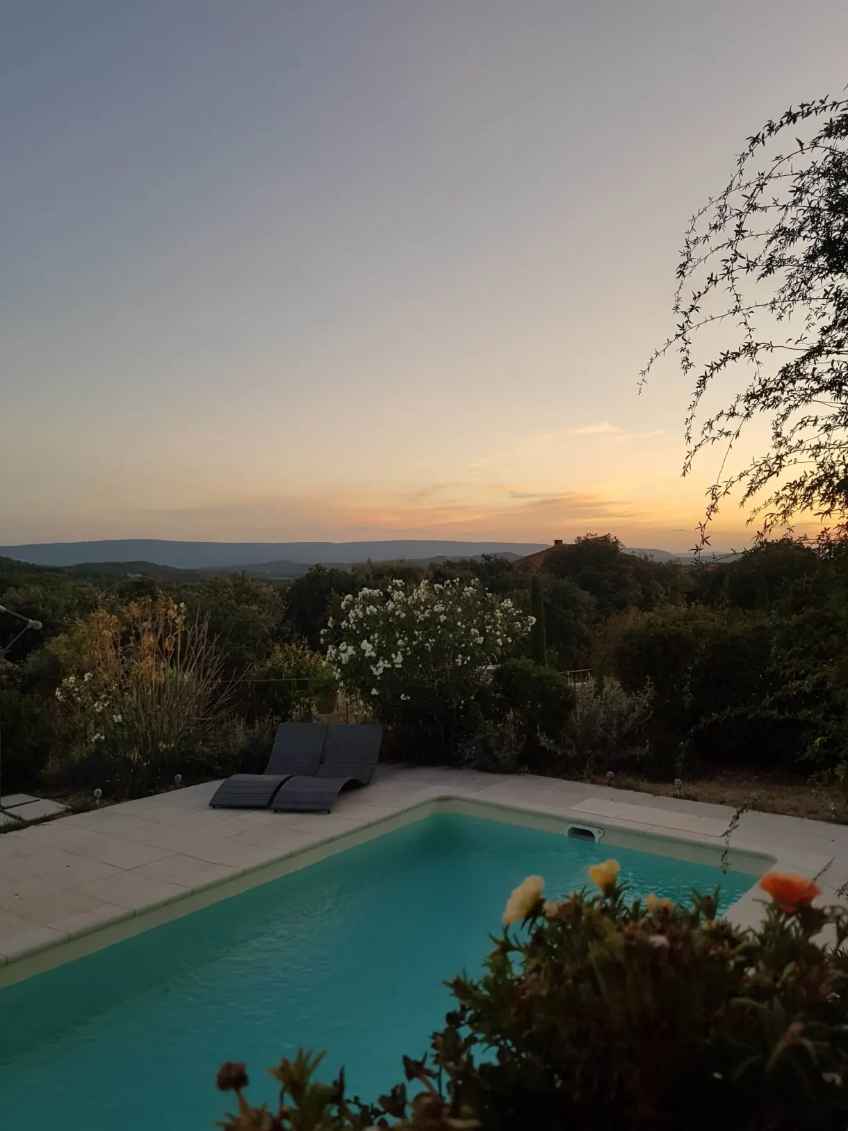 Transat solitaire au bord de la piscine sous un ciel orangé
