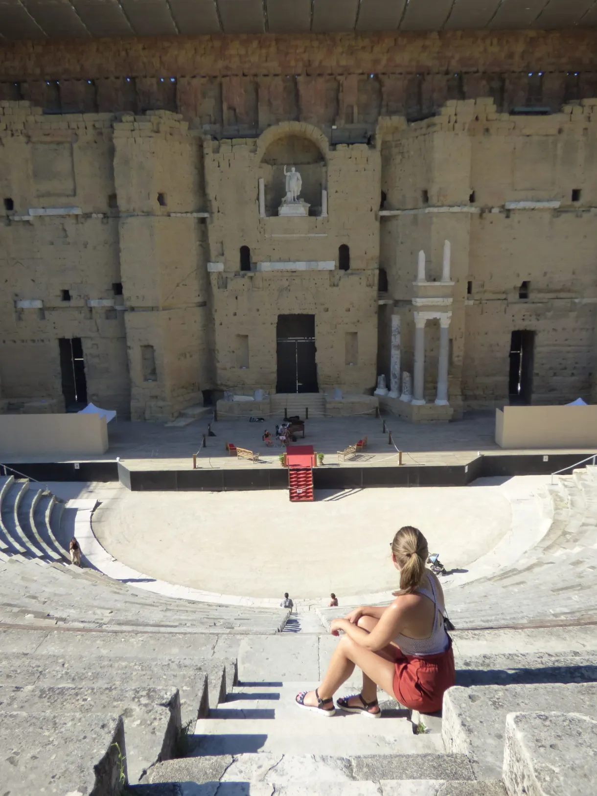 Woman sitting on the tiers facing the Roman stage wall