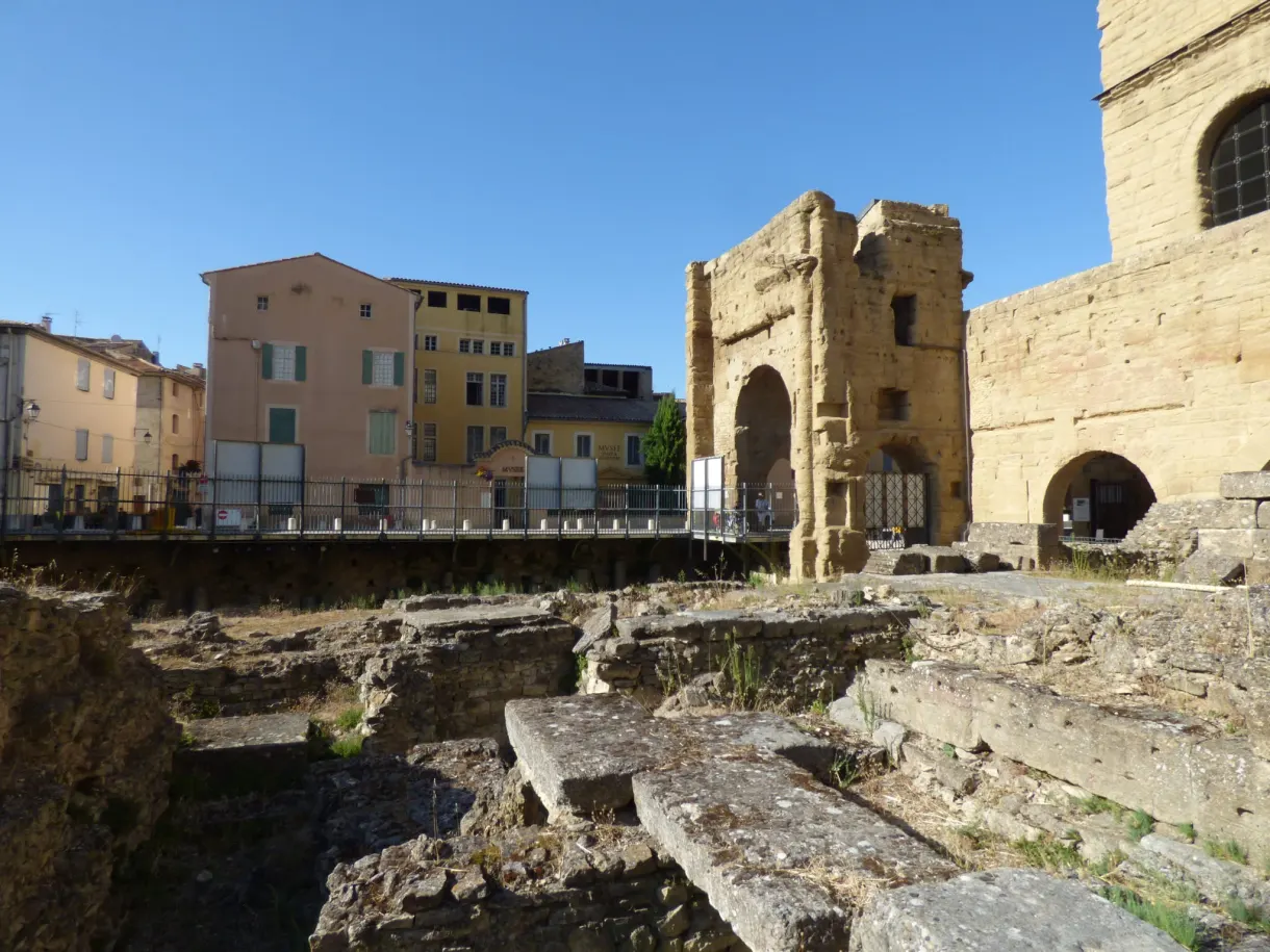 Open-air Roman remains in front of colourful houses