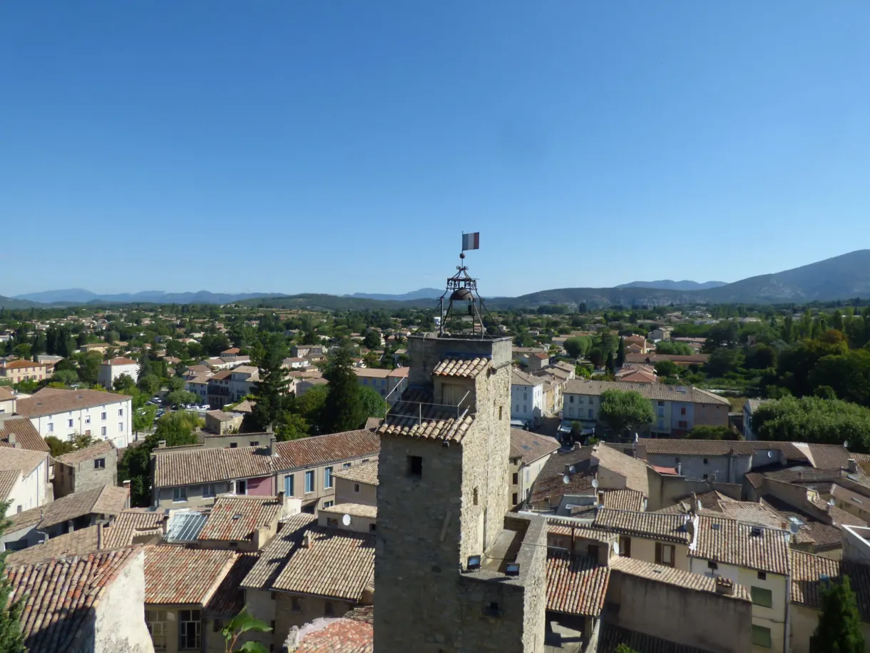 Wrought iron bell cage rising above the tiled roofs