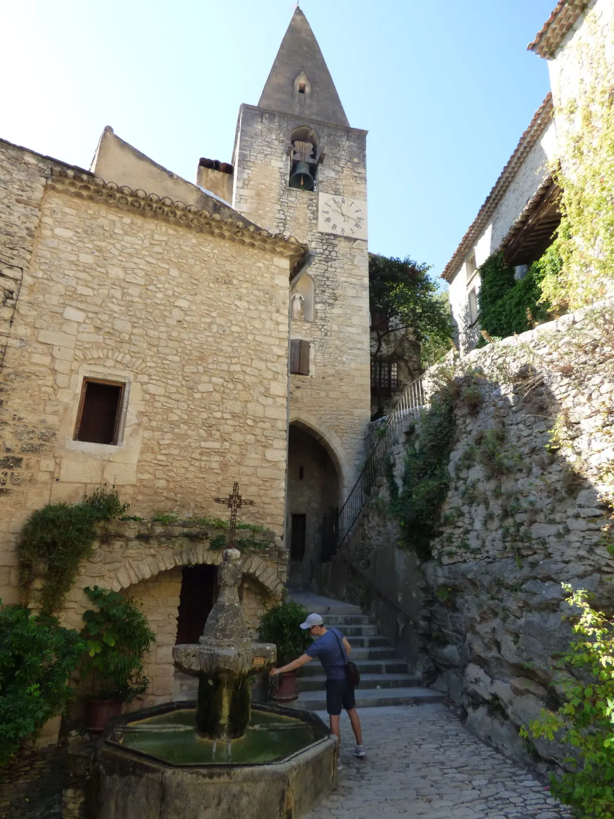 Walker at the fountain in front of the church with its bell gable