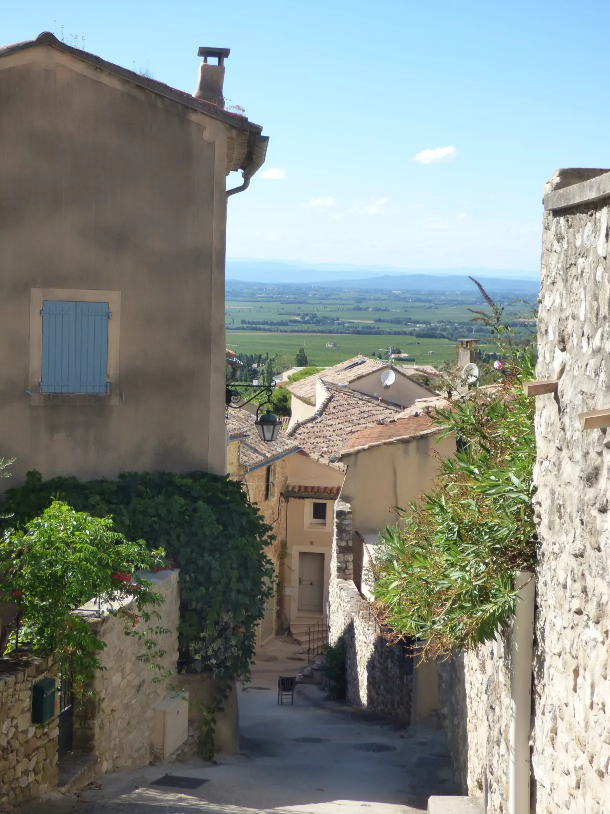 Narrow lane opening onto the plain between two facades