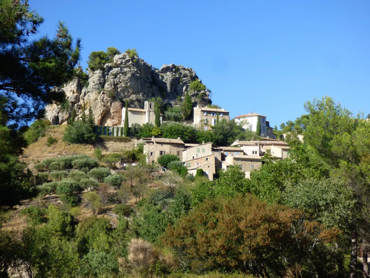 Houses of La Roque-Alric nestled beneath their rocky peak