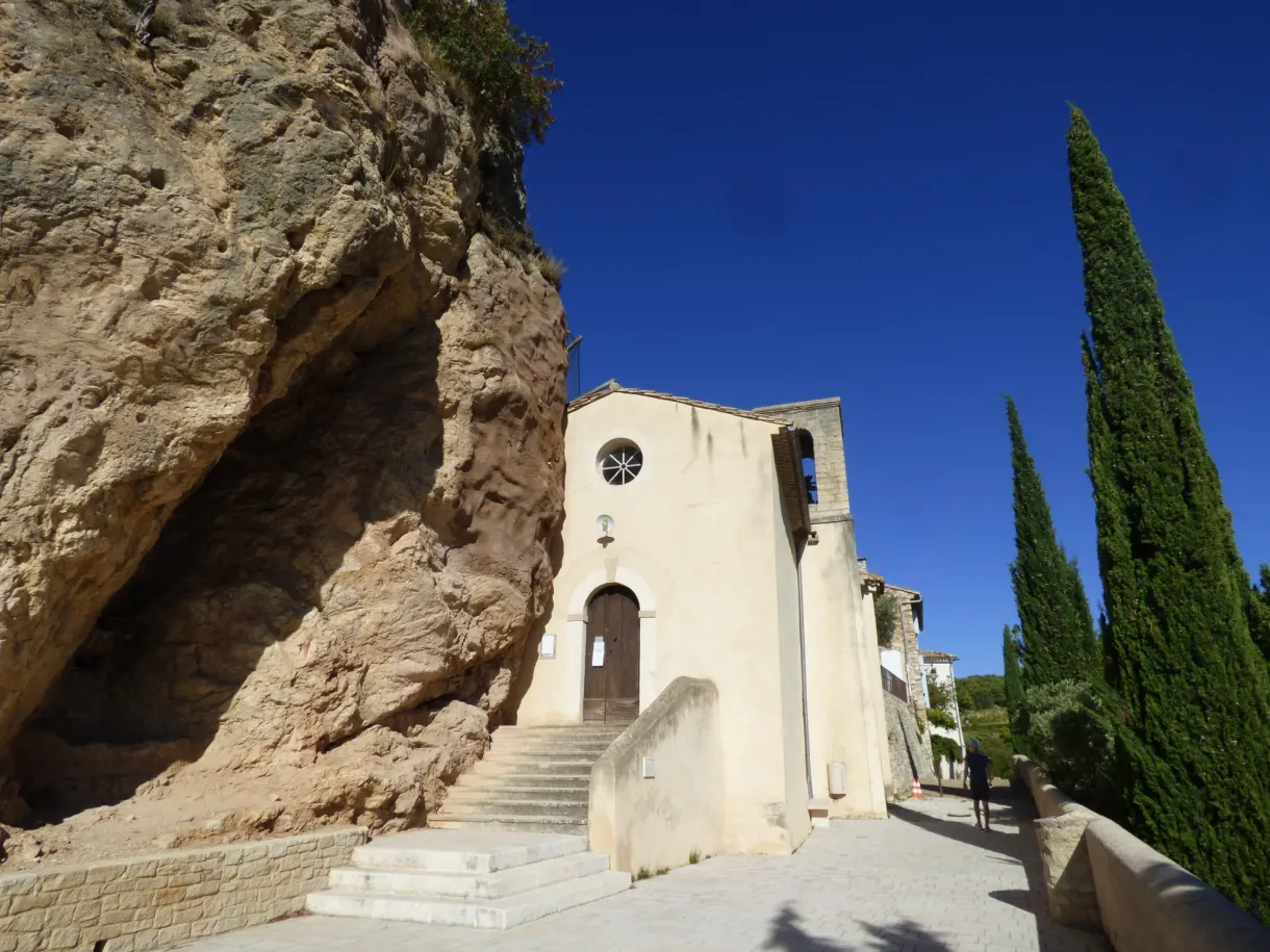 Chapel set against the rock, stone staircase and cypresses