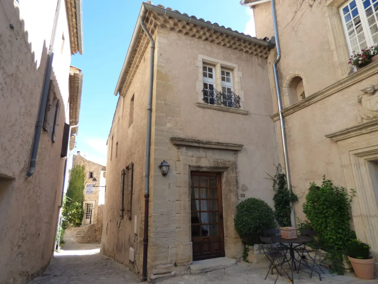 Bright lane in Le Barroux, old house and small bistro table