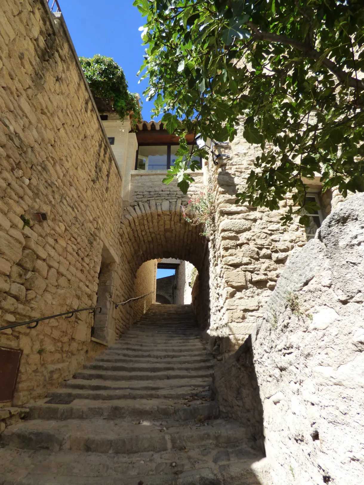 Stone staircase climbing towards a vaulted passage
