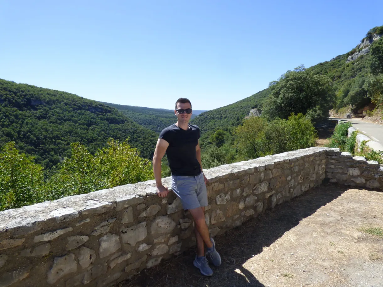 Man leaning against the wall of a viewpoint above the canyon