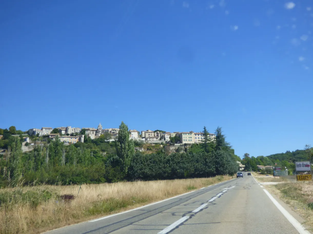Village stretched along its ridge at the end of a straight road