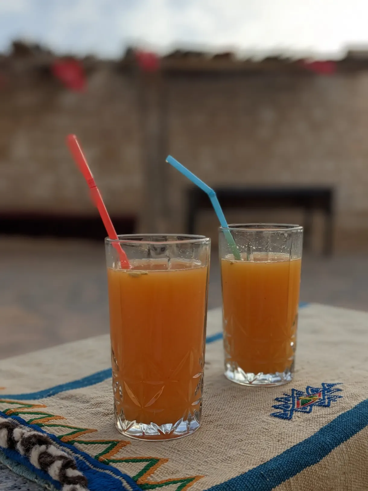 Deux jus d'orange frais sur une nappe brodée au Café Berbère Ben Jemma à Tamezret