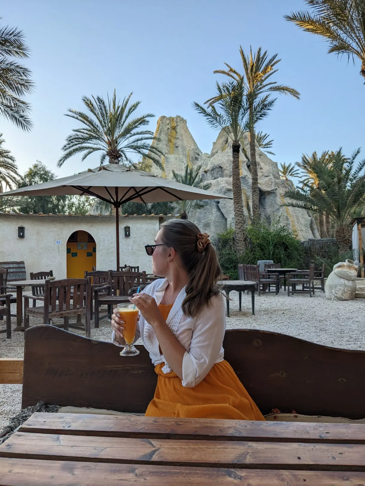 Marie avec un jus frais sous les palmiers du Chak Wak, dans la palmeraie de Tozeur