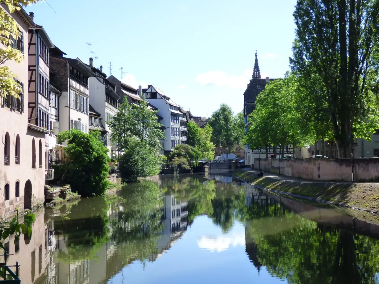 Canal lined with white houses, perfect reflection in the still water
