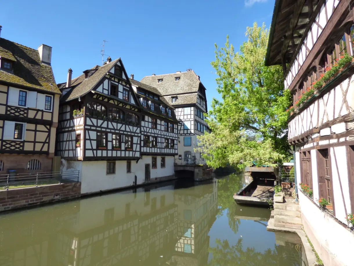 Dark half-timbered house leaning over the narrow canal