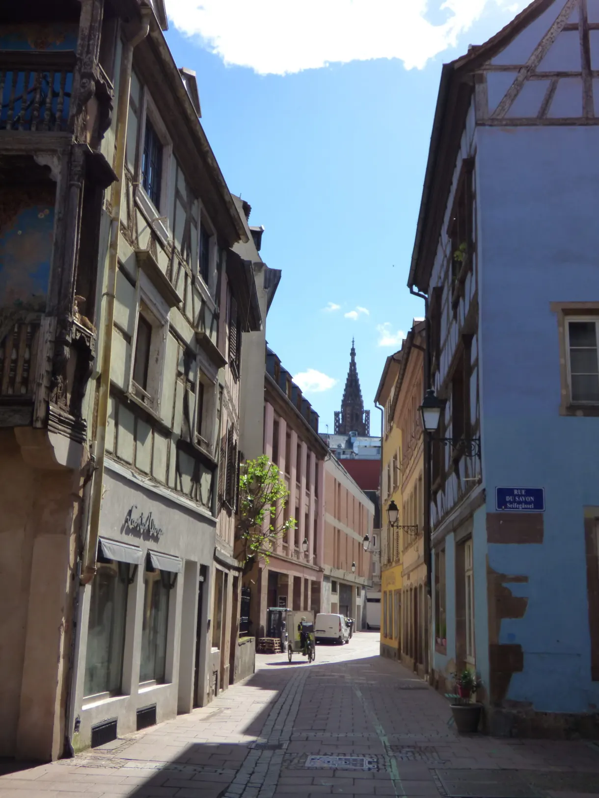 Narrow street in the centre with a Gothic spire at the end
