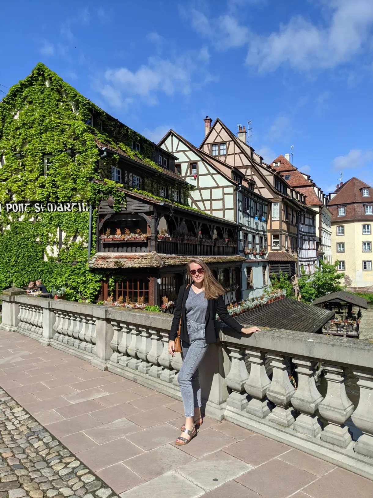 Traveller leaning on the railing in front of the ivy-covered house