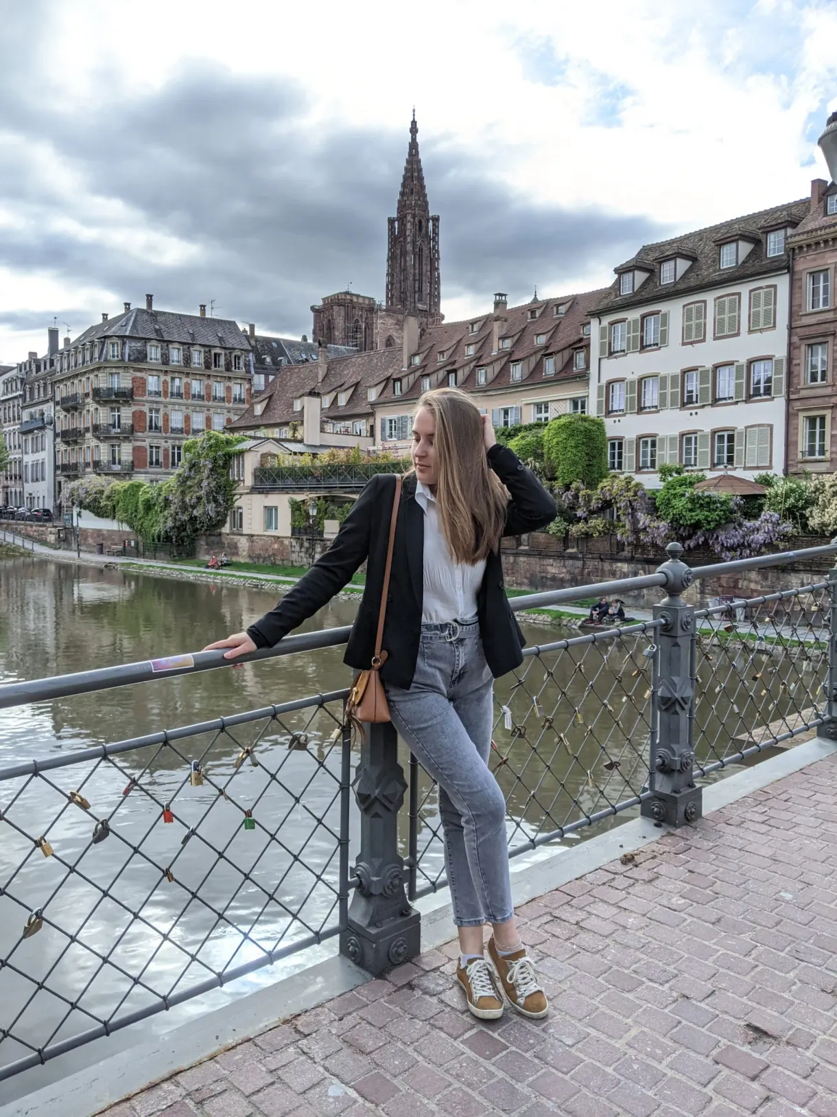 Traveller leaning on a quayside railing, cathedral in the distance