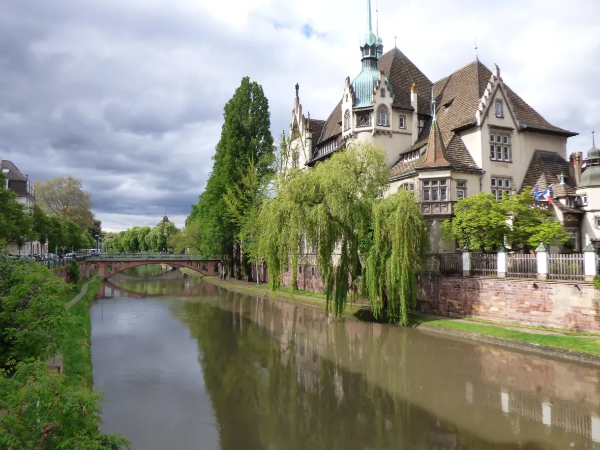 Neo-Renaissance mansion and weeping willows at the water's edge