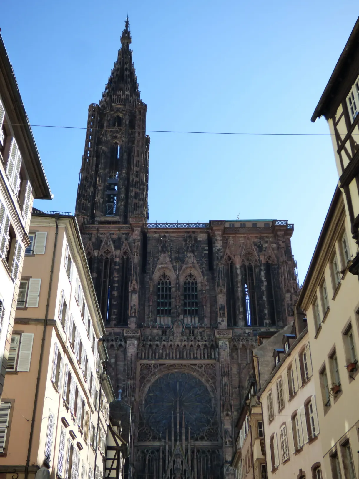 Cathedral spire rising at the end of a narrow lane