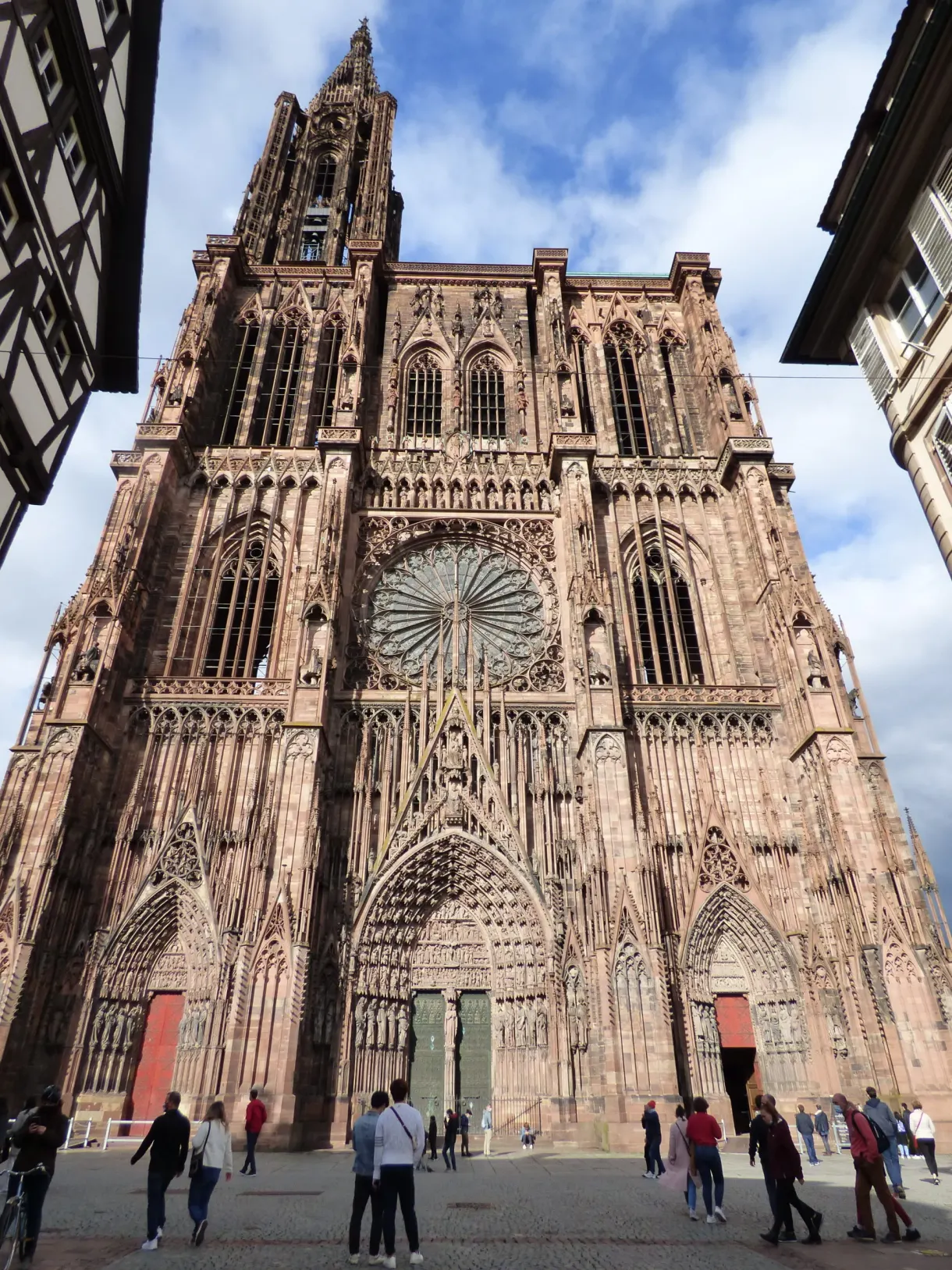 West front and rose window of the cathedral, passers-by at its foot