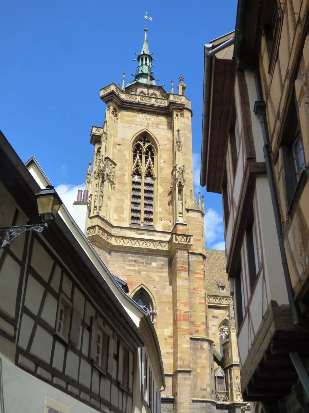 Gothic bell tower wedged between two half-timbered roofs