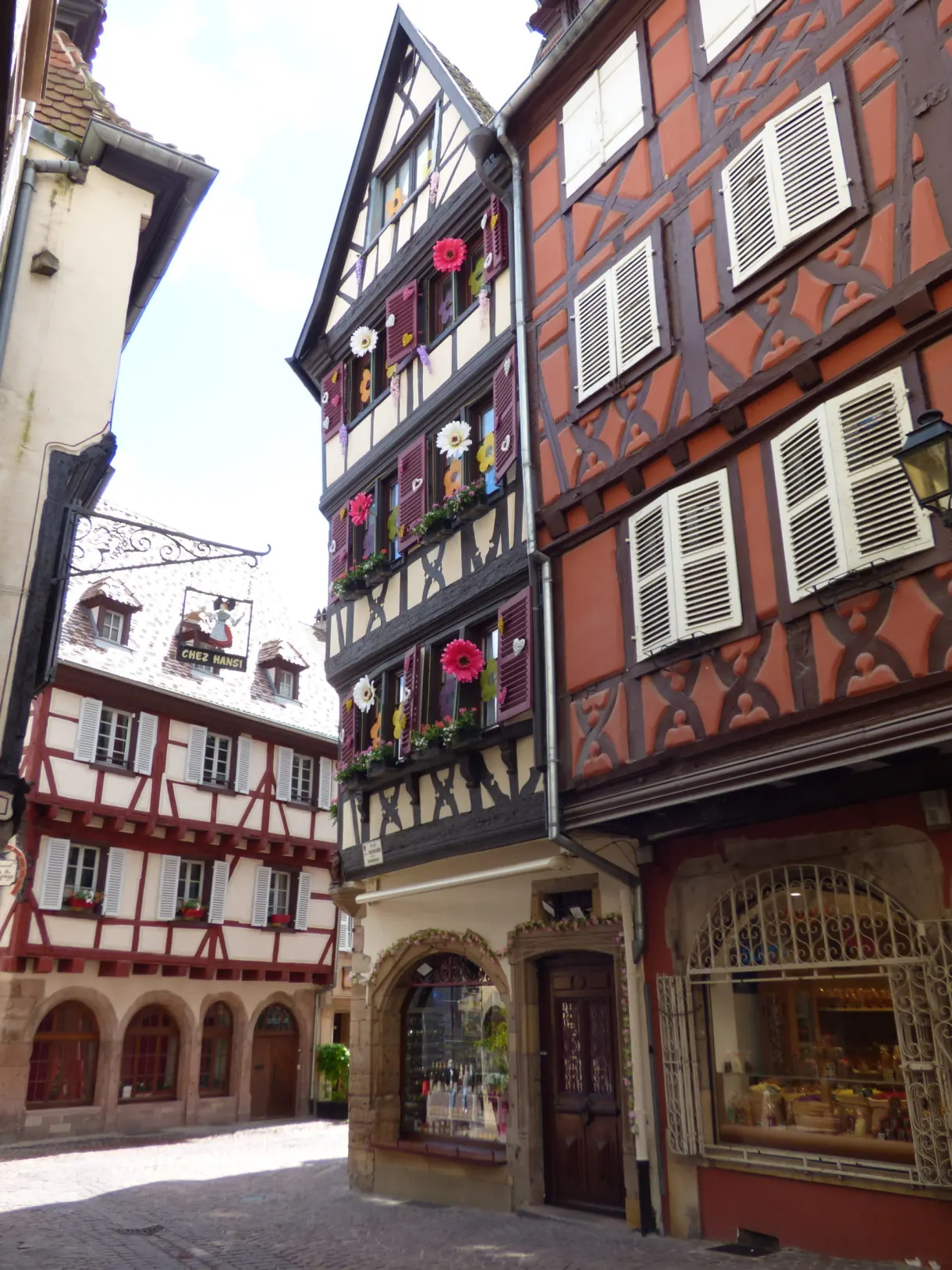Red and white flower-decked houses around a small square