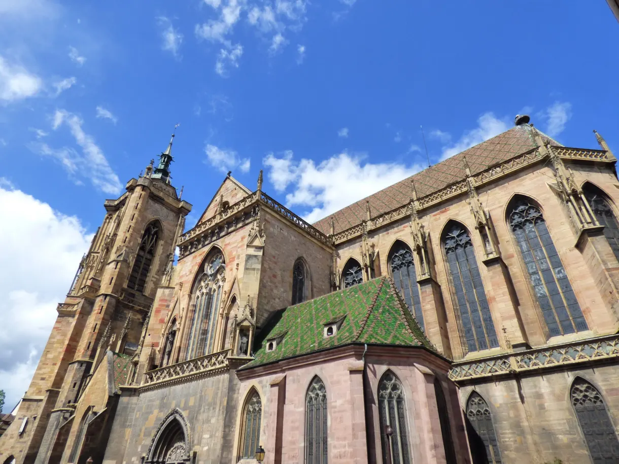 Gothic chevet in pink sandstone and its tall windows, shot from below