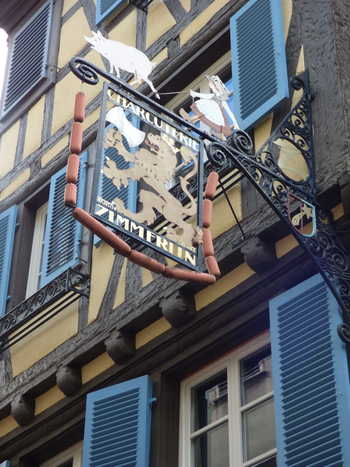Wrought iron butcher's sign decorated with white pigs