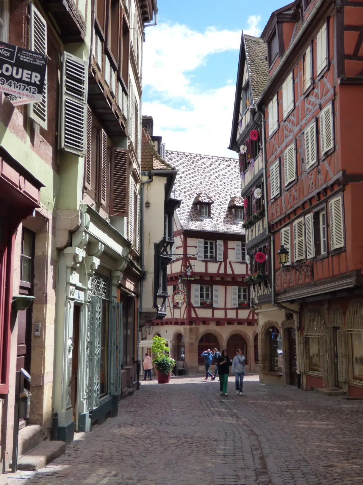 Cobbled lane descending between colourful facades