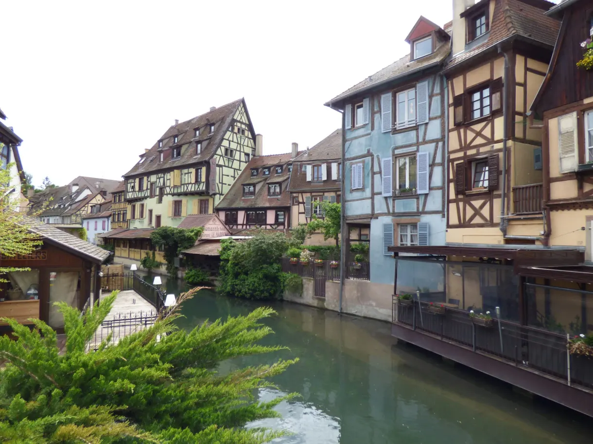 Pastel houses leaning over the canal and its greenery
