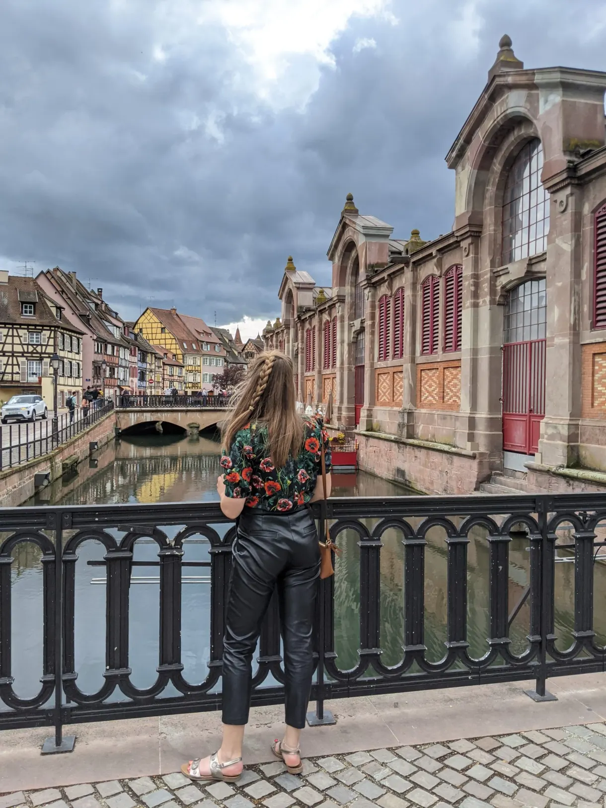 Traveller seen from behind facing the covered market from the bridge