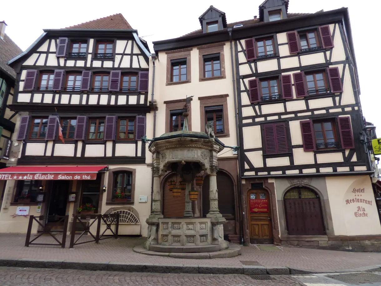 Carved Renaissance well between two tall old houses