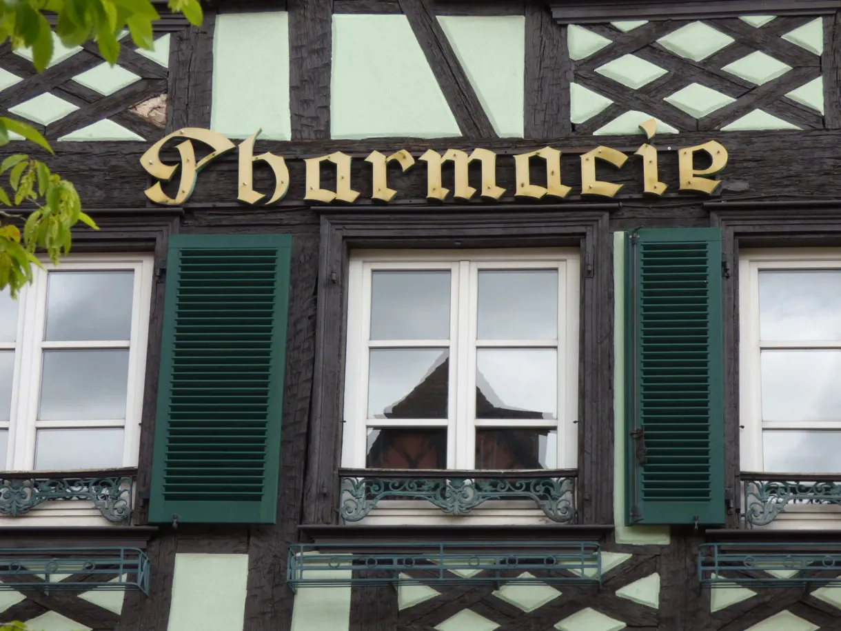 Gilded pharmacy sign on a timber-framed facade