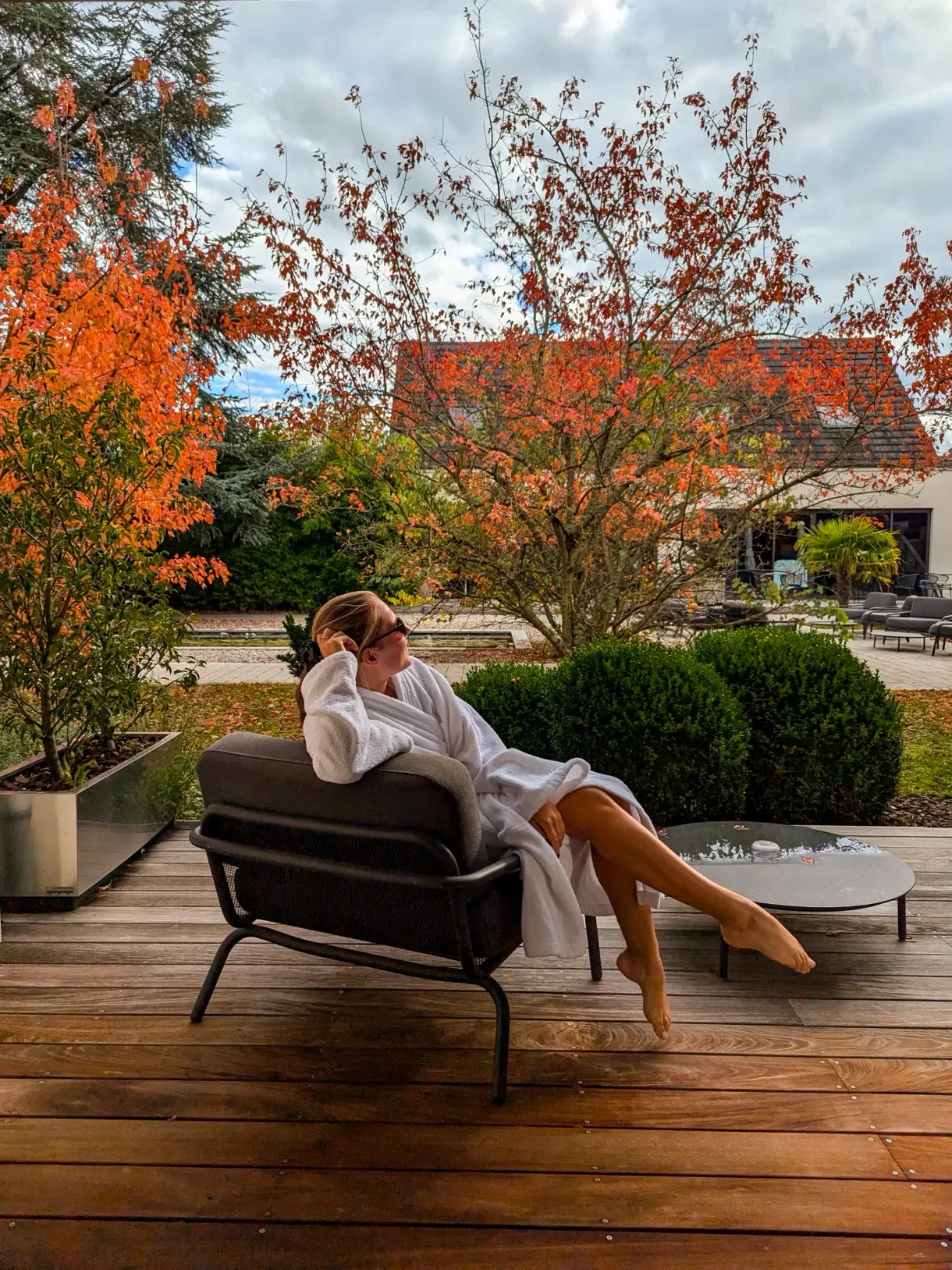 Marie in a bathrobe on the terrace of La Source des sens, a spa hotel in Alsace, in autumn